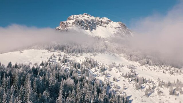 Beautiful rocky peak with misty clouds in sunny winter alps mountains nature Aerial view Outdoor background