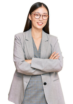 Young chinese woman wearing business clothes happy face smiling with crossed arms looking at the camera. positive person.