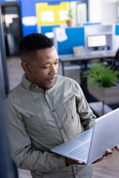 African american businessman using laptop at office with copy space