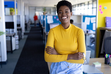 Portrait of african american businesswoman looking at camera and smiling at office with copy space