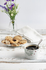 Desayuno café americano con galletas sobre mesa de madera blanca