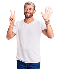 Young handsome blond man wearing casual t-shirt showing and pointing up with fingers number seven while smiling confident and happy.