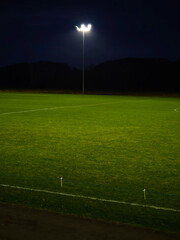 Obraz premium Training ground with grass illuminated by modern powerful LED lights. Efficient modern technology. Nobody.