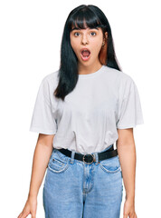 Young hispanic girl wearing casual clothes afraid and shocked with surprise expression, fear and excited face.