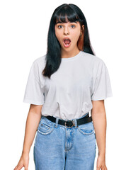 Fototapeta premium Young hispanic girl wearing casual clothes afraid and shocked with surprise expression, fear and excited face.
