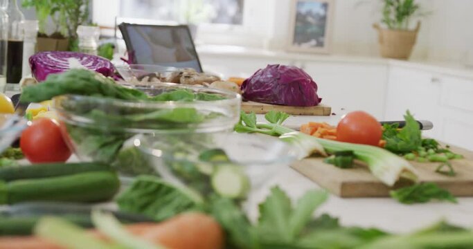 Close up of kitchen with vegetables and tablet on countertop