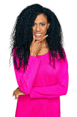 Middle age african american woman wearing casual clothes looking confident at the camera smiling with crossed arms and hand raised on chin. thinking positive.