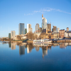 Fototapeta na wymiar scenic view to skyline of Frankfurt am Main with reflection of the skyline in river Main.