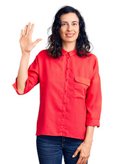 Young beautiful hispanic woman wearing casual clothes showing and pointing up with fingers number five while smiling confident and happy.