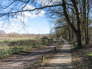 Unpaved road with a bicycle path through a Dutch landscape near Nijmegen, The Netherlands