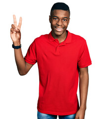 Young african american man wearing casual red t shirt smiling looking to the camera showing fingers doing victory sign. number two.