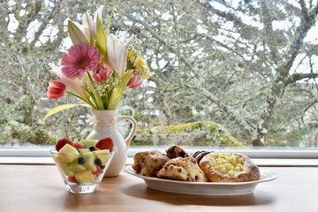 Easter spring brunch breakfast with tasty pastries and bouquet of flowers
