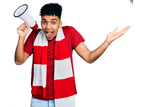 Young african american man football hooligan holding megaphone celebrating victory with happy smile and winner expression with raised hands