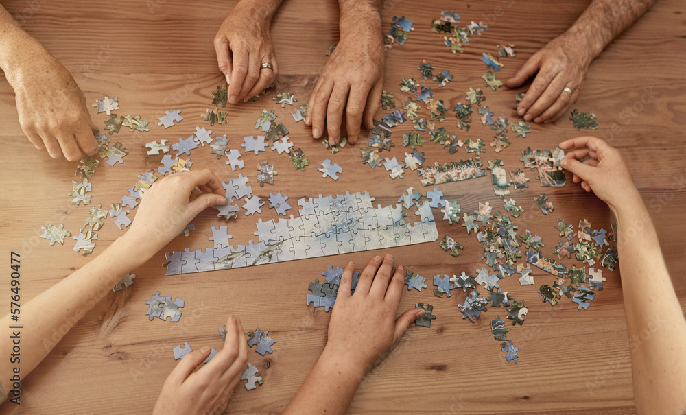 Poster jigsaw solutions. shot of a group of people building a puzzle together.