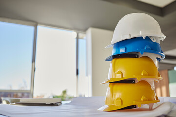 Building, helmets and architect equipment on table for construction safety, security or industrial...