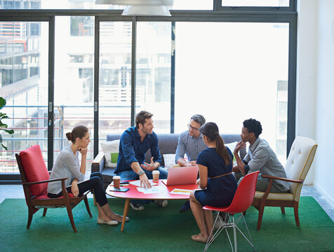 Ideas are flowing. Shot of a group of office workers talking together in a meeting room.