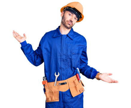 Young hispanic man wearing worker uniform clueless and confused expression with arms and hands raised. doubt concept.