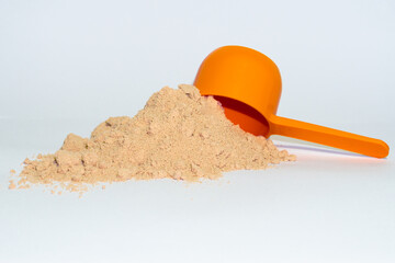 Chocolate protein powder with its spon at the right, half sided