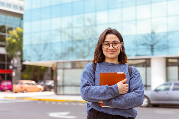 Joven mujer, con mochila, auriculares, preparada para comenzar la universidad. Fotografía plano medio.