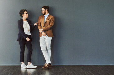 You gain so much from mingling. Shot of two designers having a conversation while leaning against a...