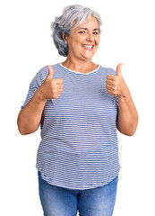 Senior woman with gray hair wearing casual striped clothes success sign doing positive gesture with hand, thumbs up smiling and happy. cheerful expression and winner gesture.