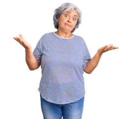Senior woman with gray hair wearing casual striped clothes clueless and confused expression with arms and hands raised. doubt concept.