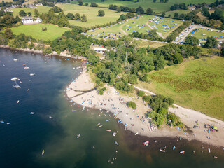Crowds of people on a small lakeside beach in the middle of summer (Ullswater, Lake District, England)