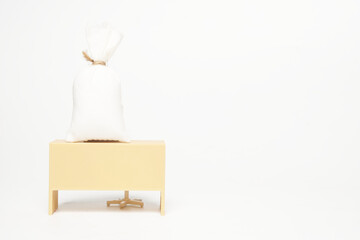 A picture of miniature desk with money bag on copyspace white background. Payroll and compensation...