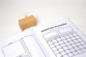 Selective focus picture of miniature table of office desk and monthly planner book.