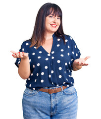 Young plus size woman wearing casual clothes smiling cheerful with open arms as friendly welcome, positive and confident greetings