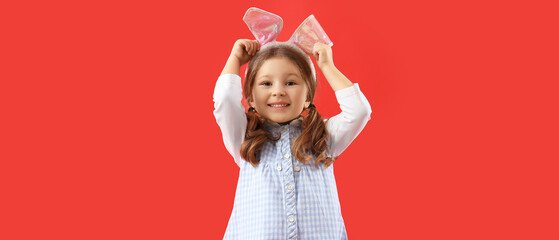 Little girl with Easter bunny ears on red background