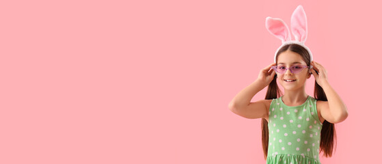 Cute little girl with bunny ears on pink background with space for text