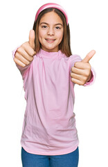 Beautiful brunette little girl wearing casual turtleneck sweater approving doing positive gesture...