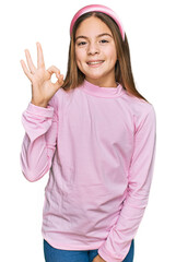 Obraz na płótnie Canvas Beautiful brunette little girl wearing casual turtleneck sweater smiling positive doing ok sign with hand and fingers. successful expression.
