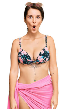 Young brunette woman with short hair wearing bikini scared and amazed with open mouth for surprise, disbelief face