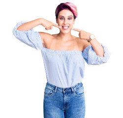 Young beautiful woman with pink hair wearing casual clothes smiling cheerful showing and pointing with fingers teeth and mouth. dental health concept.