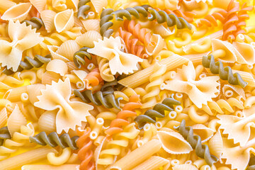Different types of raw pasta as background, closeup