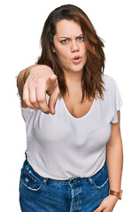 Fototapeta premium Young plus size woman wearing casual white t shirt pointing displeased and frustrated to the camera, angry and furious with you