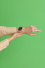 Woman with stylish wristwatch on green background