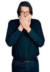 Middle age caucasian man wearing casual clothes and glasses shocked covering mouth with hands for mistake. secret concept.