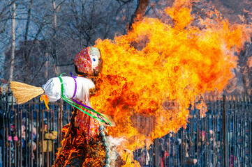 Large ritual fire with a beautiful texture. Burning doll from branches and straw. Maslenitsa is a...
