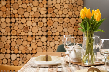 Table setting for International Women's Day celebration with tulip flowers in interior of room