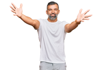 Middle age handsome man wearing casual white tshirt looking at the camera smiling with open arms for hug. cheerful expression embracing happiness.