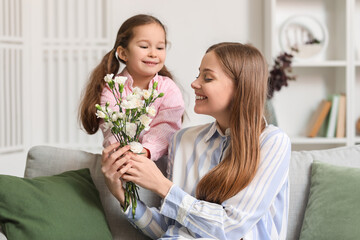 Fototapeta na wymiar Cute little girl greeting her mother with flowers at home on holiday