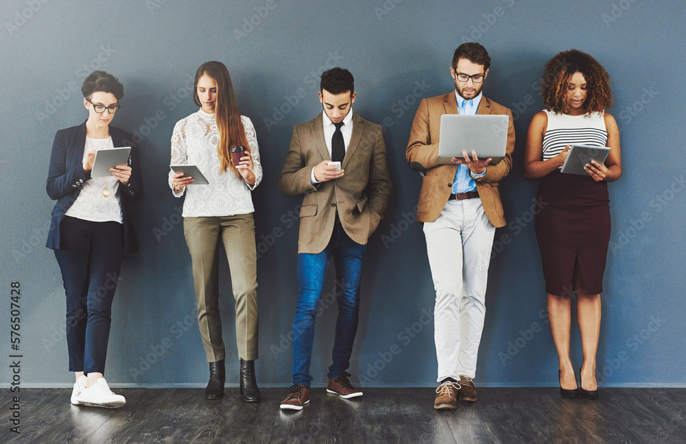 Poster wireless entertainment for the wait. studio shot of a group of businesspeople using wireless technol