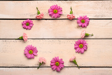 Frame made of beautiful pink flowers on light background