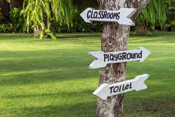 Concept of child development in nature. Wooden pointer in the kindergarten outdoors.