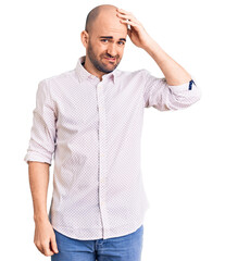 Fototapeta premium Young handsome man wearing elegant shirt confuse and wonder about question. uncertain with doubt, thinking with hand on head. pensive concept.