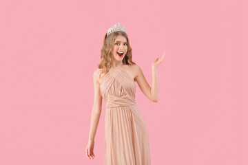 Happy teenage girl in tiara and prom dress on pink background © Pixel-Shot