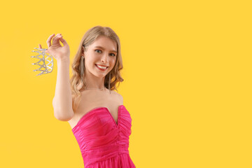 Teenage girl in pink prom dress with crown on yellow background - obrazy, fototapety, plakaty